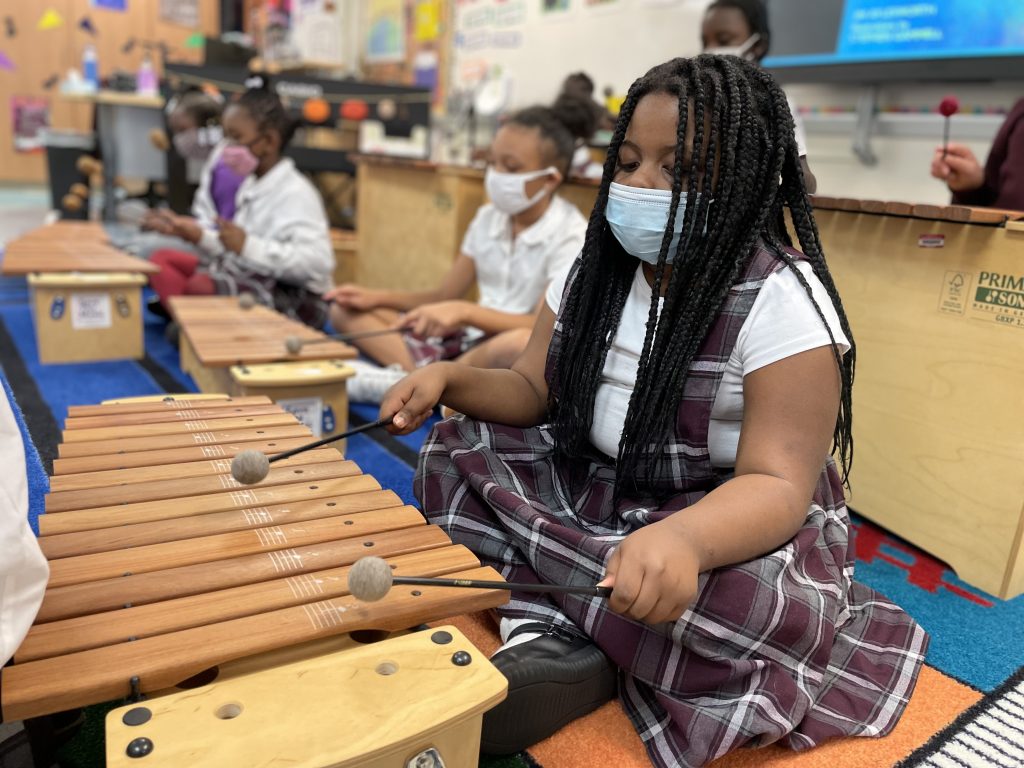 A student plays the xylophone during a music class at Charity Adams.